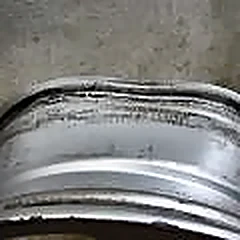Marginea deteriorată a unei jante din aluminiu, văzută de aproape