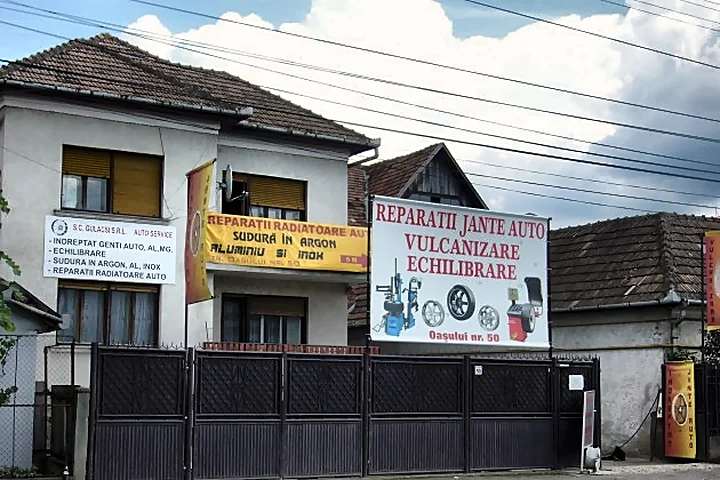 Fațada atelierului în fotografiile vechi: aceeași poartă, cu bannerele pentru jante, sudură în argon și radiatoare