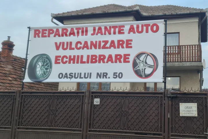 Fațada atelierului astăzi, cu bannerul Reparații jante auto, Vulcanizare, Echilibrare