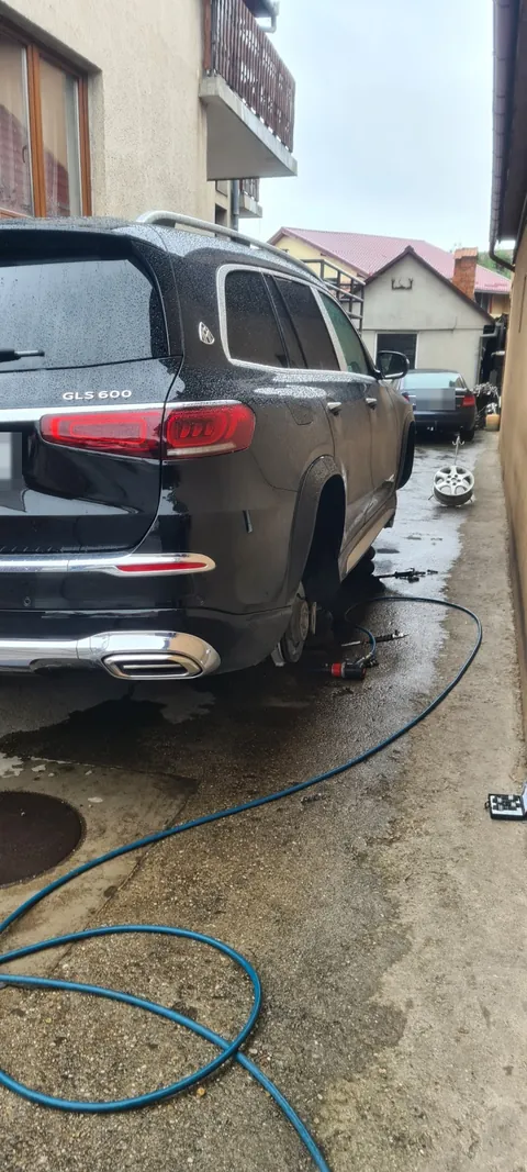 Mercedes-Maybach GLS 600 negru, văzut din spate, cu roata din spate demontată